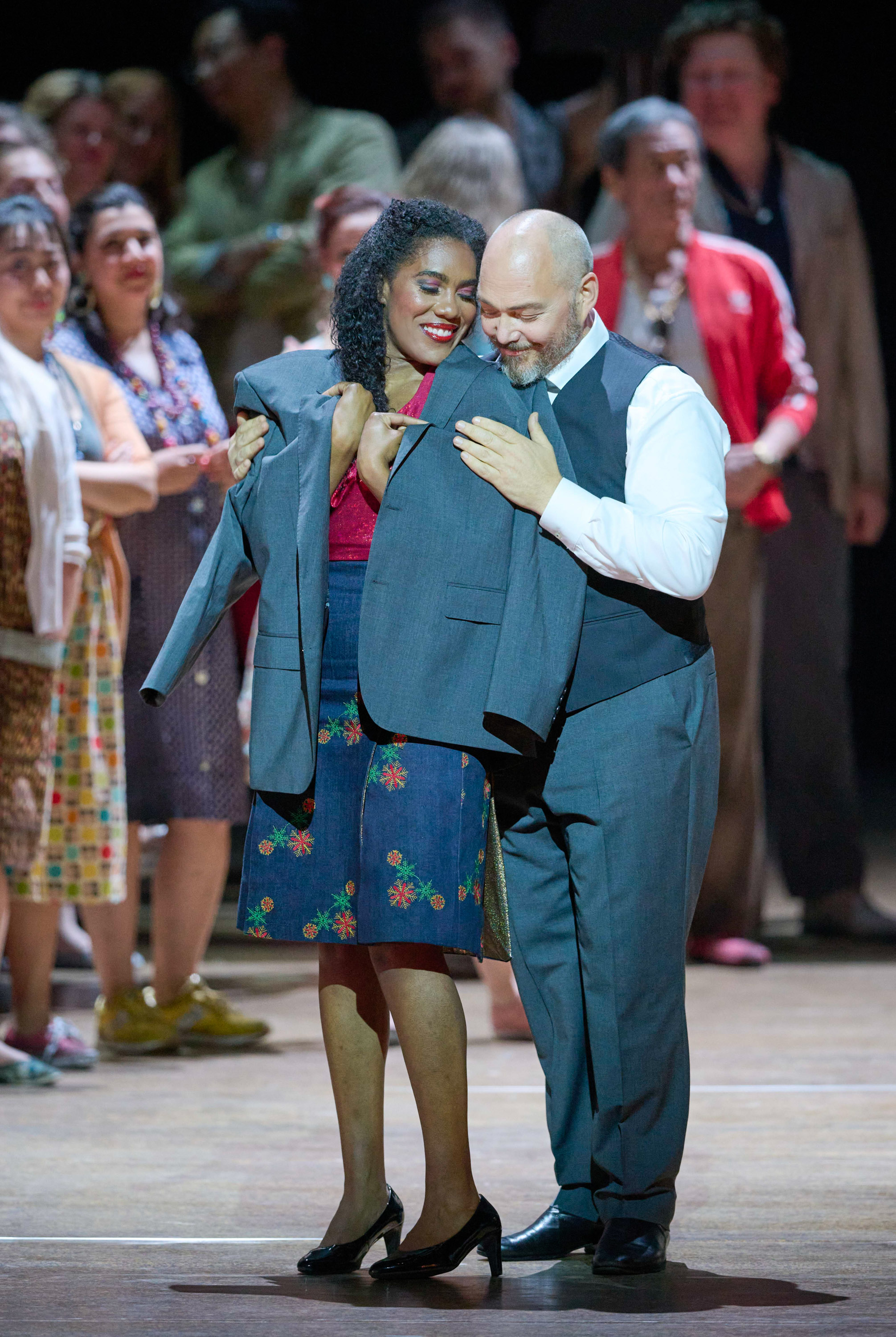 Ein Mann legt sein dunkelblaues Sakko über eine Frau, die sich an ihn schmiegt. 