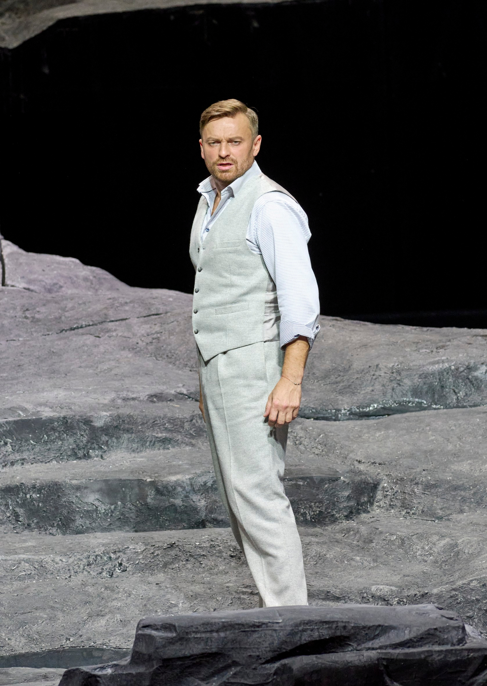 Ein Mann steht vor einer Felsenlandschaft.