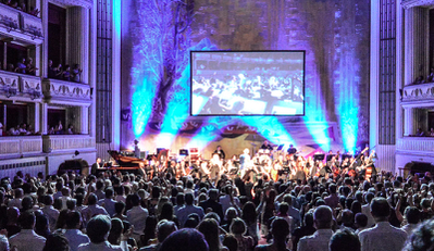 Stimmungsvoll beleuchteter Zuschauerraum mit Blick auf die Bühne.